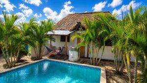 a woman sitting in a chair next to a house with a swimming pool at Aloha Popoyo in Playa Santana