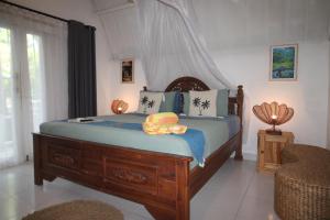 a bedroom with a large wooden bed with blue sheets at New Balengku Dua Hotel - Adults Only in Gili Islands