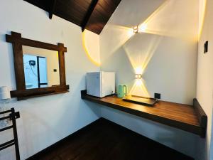 a room with a counter with a microwave and a mirror at Mango Garden Eco Resort sigiriya in Sigiriya