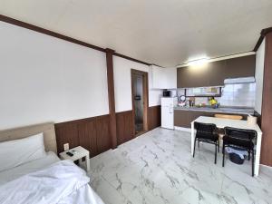 a bedroom with a bed and a table and a kitchen at Stay something in Ch'ŏnbu-ri +44 photos