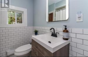 a bathroom with a toilet and a sink and a mirror at Central, Dog Friendly, Parking in Saint John +14 photos