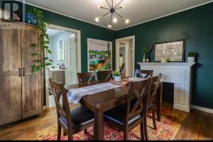 a dining room with a table and chairs and green walls at Central, Dog Friendly, Parking in Saint John