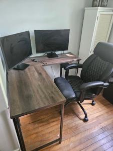 a desk with two computer monitors and a chair at Central, Dog Friendly, Parking in Saint John