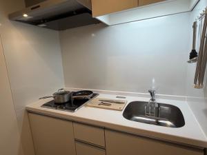 a kitchen with a sink and a stove at レジデグローバル熊本 in Kumamoto
