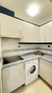 a kitchen with a washing machine and a sink at La Envía Terraza in La Envia