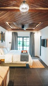 a bedroom with a large bed and a chandelier at Bliss Villa By Happiness Philippines in El Nido +12 photos
