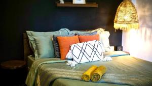 a bed with colorful pillows on top of it at Happiness Villas in El Nido