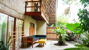 a balcony of a house with a bench and a table at Happiness Native Villa in El Nido