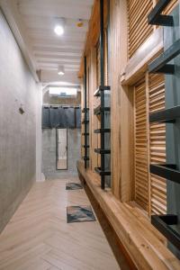 a hallway with wood flooring and a walk in shower at Happiness Hostel Siargao in General Luna
