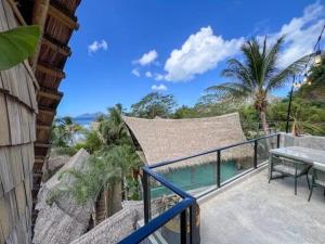 a balcony with a table and a view of the ocean at Happiness Kulambo Villa El Nido in El Nido