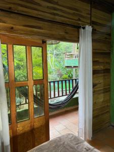 a room with a hammock and a balcony with a window at Hotel El Santuario in Minca +59 photos