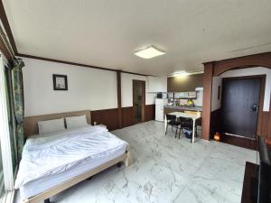 a bedroom with a bed and a table in it at Stay something in Ch'ŏnbu-ri