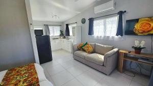 a living room with a couch and a kitchen at Mama's Mountain Views in Avarua