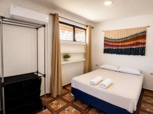 a bedroom with a bed and a painting on the wall at Aloha Popoyo in Playa Santana