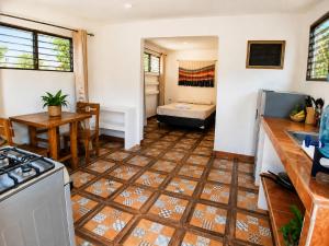 a kitchen with a stove and a table and a room at Aloha Popoyo in Playa Santana