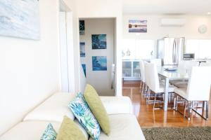a living room with a white couch and a dining room at '128 The Esplanade' - Beachside holiday home with swimming pool in Robe in Robe