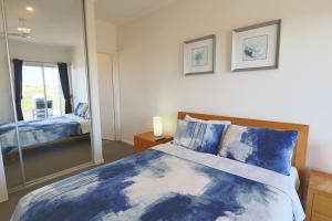 a bedroom with a large bed with a mirror at '128 The Esplanade' - Beachside holiday home with swimming pool in Robe in Robe +26 photos