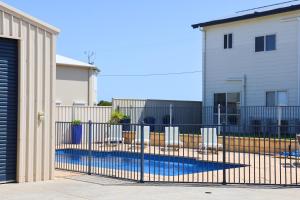 a fence with chairs in front of a house at '128 The Esplanade' - Beachside holiday home with swimming pool in Robe in Robe