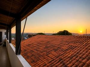 a roof with a sunset in the background at Apartamentos-3-6-8-Pousada Itapetininga in Itapetininga