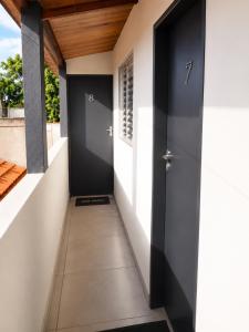 a hallway of a house with a black door at Apartamentos-3-6-8-Pousada Itapetininga in Itapetininga