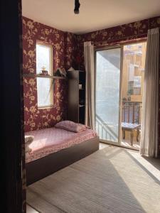a bedroom with a bed and a large window at Soaltee city apartments in Kathmandu