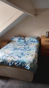 a bed with a blue comforter and two pillows at AAA lodge in Middlesbrough