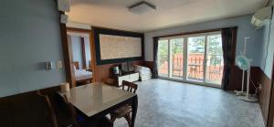 a living room with a table and a balcony at Stay something in Ch'ŏnbu-ri