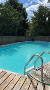 a blue swimming pool with a wooden deck at Comfort Home Toronto in Toronto
