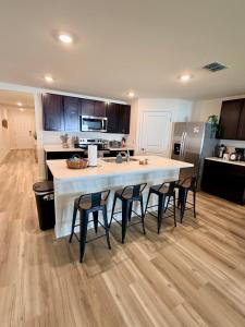 a kitchen with a large white island with chairs around it at Paradise in the Springs in Citrus Springs
