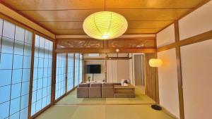 a living room with a couch and a chandelier at Tabinoteitaku 和-WA- in Sendai