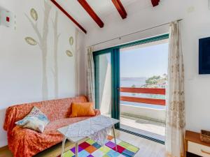 a living room with a couch and a large window at Alluring Apartment by the Sea in Stomorska