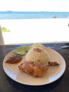 a plate of food with rice and vegetables on a table at Ten RooMs in Telukbakau