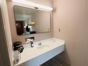 a bathroom with a sink and a large mirror at Prospector Inn in Escalante