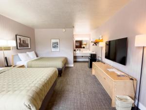 a hotel room with two beds and a flat screen tv at Prospector Inn in Escalante