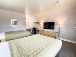 a hotel room with two beds and a flat screen tv at Prospector Inn in Escalante +15 photos