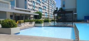 a large swimming pool in front of a building at Mike's Place at Marina Spatial in Dumaguete