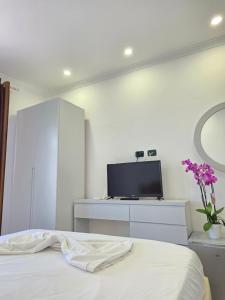 a bedroom with a bed and a dresser with a tv at Crown Villa in Golem +21 photos