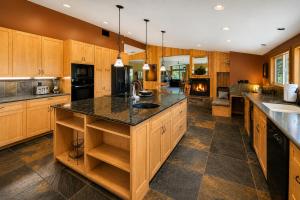 a large kitchen with wooden cabinets and a black counter top at River Heights Home cabin in Leavenworth +80 photos