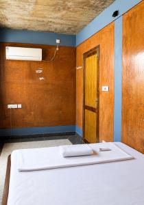 a room with a bed and a door at Avora Auroville in Auroville +6 photos