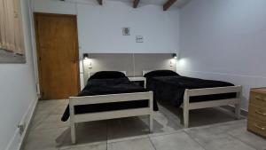 a room with two beds and a door at TRINIDAD in San Juan