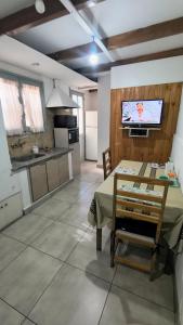 a kitchen and dining room with a table and a tv at TRINIDAD in San Juan