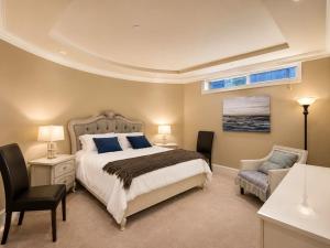 a bedroom with a bed and a desk and a chair at Campus Haven Near YVR UBC Downtown in Vancouver