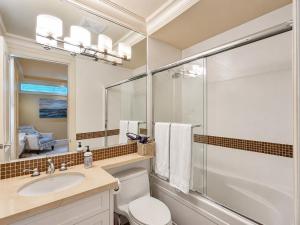 a bathroom with a toilet and a sink and a mirror at Campus Haven Near YVR UBC Downtown in Vancouver
