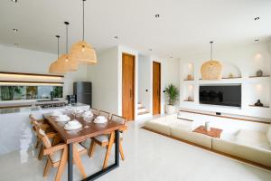 a dining room and living room with a table and chairs at Blanca Karma Villas in Uluwatu