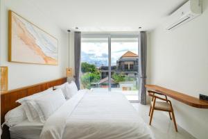 a bedroom with a large white bed and a window at Blanca Karma Villas in Uluwatu +73 photos