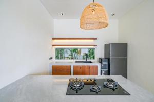 a kitchen with a stove and a counter top at Blanca Karma Villas in Uluwatu