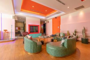 a living room with two green chairs and a table at Vogue Boutique Motel in Yangmei