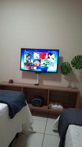 a flat screen tv sitting on a shelf in a bedroom at Quarto confortável em Diamantina in Diamantina