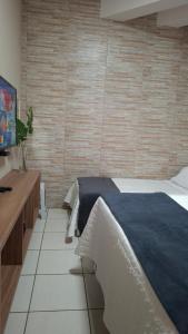 a bedroom with a bed and a wooden wall at Quarto confortável em Diamantina in Diamantina
