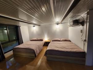 two beds in a room with a ceiling at Porjai's Lakeview in Phetchabun